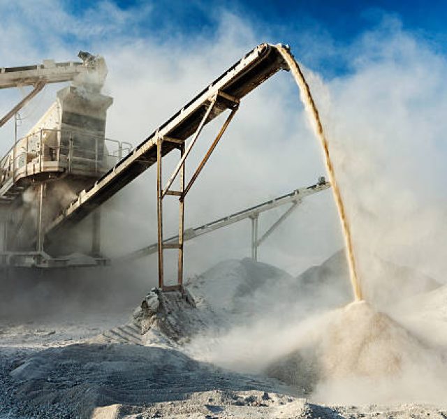 Industrial background - crusher rock stone crushing machine at open pit mining and processing plant for crushed stone, sand and gravel